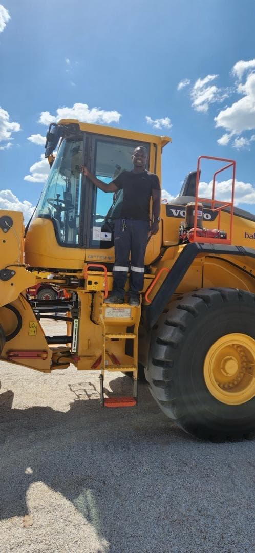 Vertical project photo showing heavy machinery and field support activity