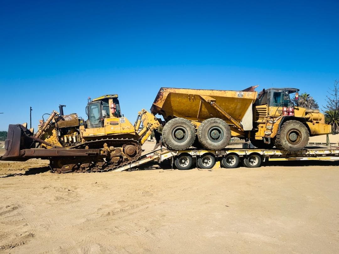 Bulldozer and dump truck loaded on a transport trailer