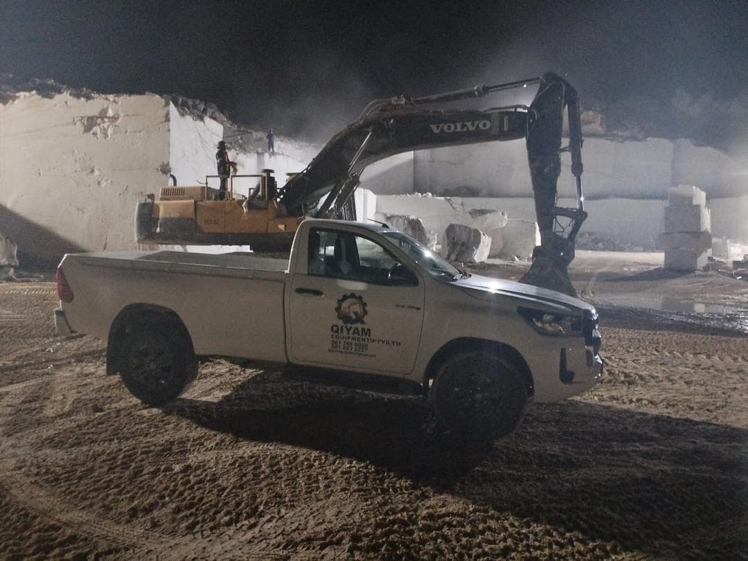 Qiyam support vehicle beside an excavator at night on site