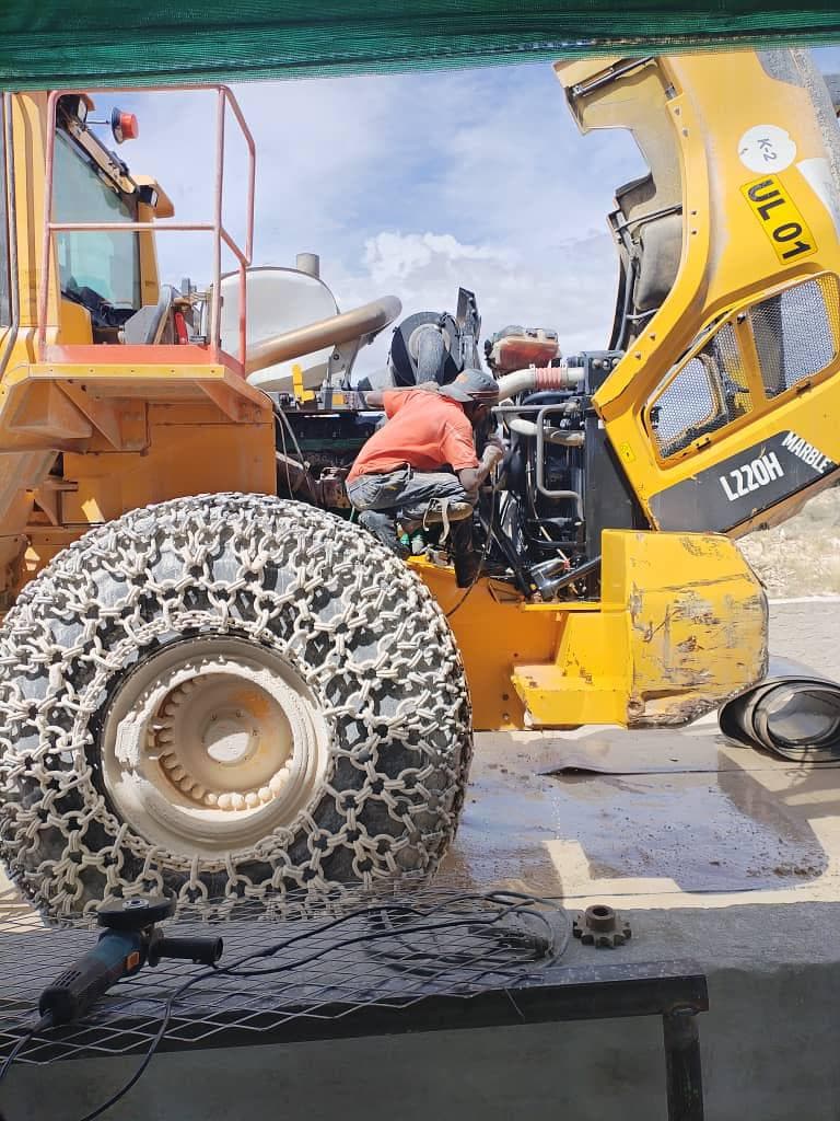 Technician carrying out servicing work on a wheel loader in the field